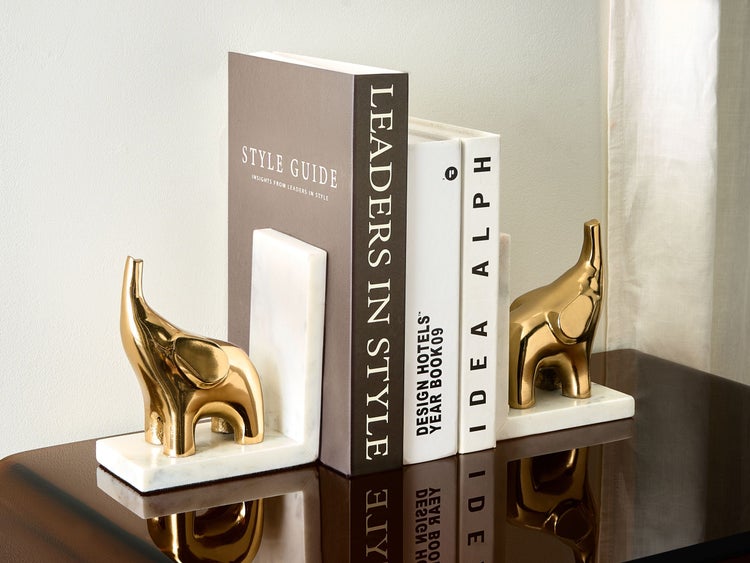 Dekorative Buchstützen mit Elefantenmotiven aus Marmor und Metall zwischen Büchern