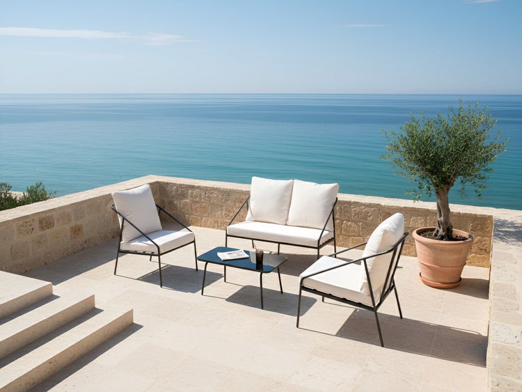 Sitzgruppe mit Sofa, zwei Sesseln und Tisch auf einer Terrasse mit Meerblick