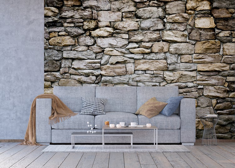 Wohnzimmer mit Sofa vor einer Steinwandtapete