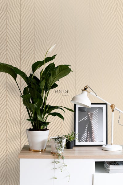 Dekorative Tapete mit Fischgrätenmuster in einem hellen Raum mit Pflanzen und Lampe.