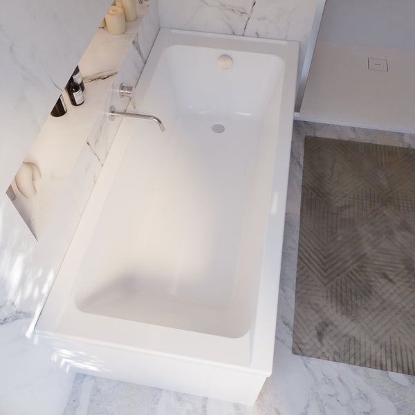 Aufnahme einer weißen Badewanne mit Armatur in einem Badezimmer mit Marmorfliesen.