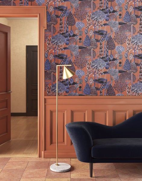 Szene mit dekorativer Waldtapete, Stehlampe und Sofa.