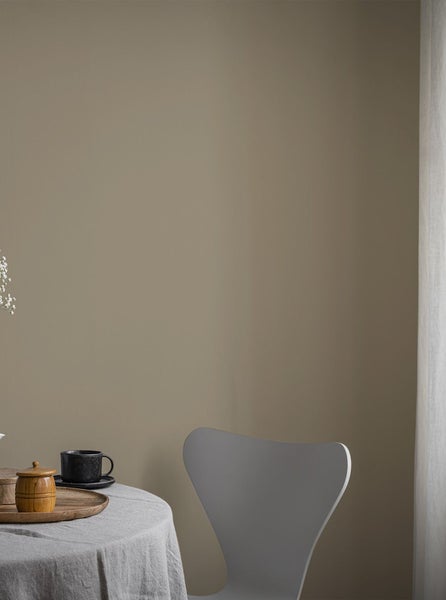 Wohnraum mit gedecktem Tisch und Stuhl vor einer gestrichenen Wand