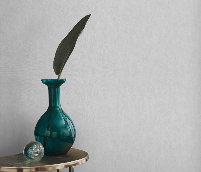 Dekorative Szene mit Vase, Blatt und Kugel auf einem Tisch