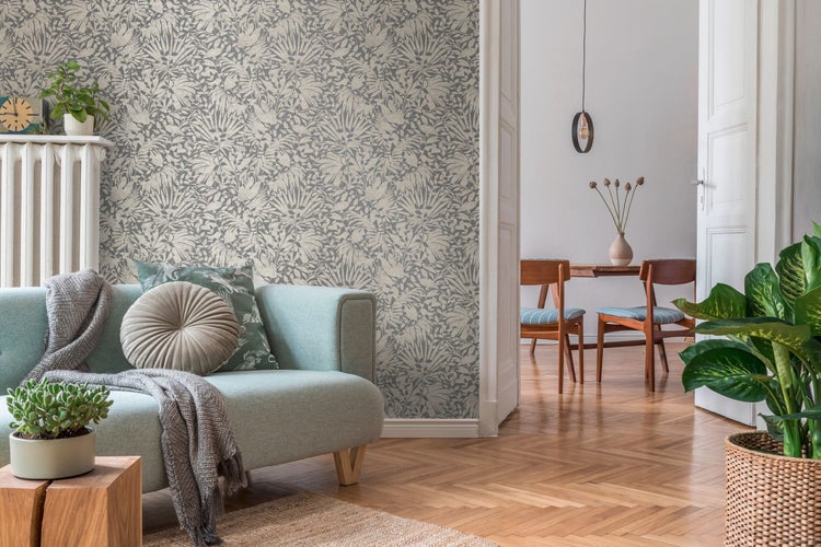 Dekorative Tapete mit Pflanzenmuster, Tisch mit Pflanzen, Buchstapel und Vogelbild