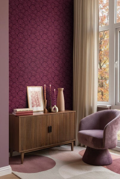 Wohnzimmer mit Kommode, Sessel und gemusterter Tapete