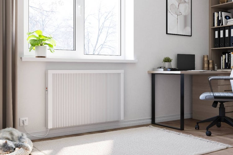 Ein elektrischer Flachheizkörper an einer Wand montiert in einem modern eingerichteten Büro mit Schreibtisch und Fenster.