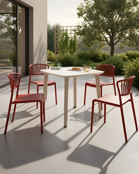 Quadratischer Tisch mit vier Stühlen im Garten