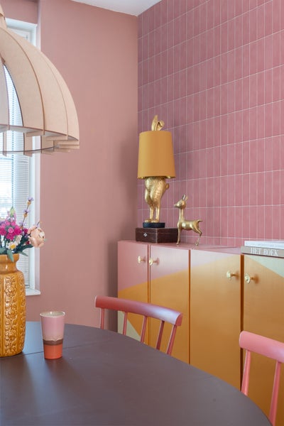 Interieuransicht eines Esszimmers mit Tisch, Stühlen, Schrank und Dekorationsgegenständen