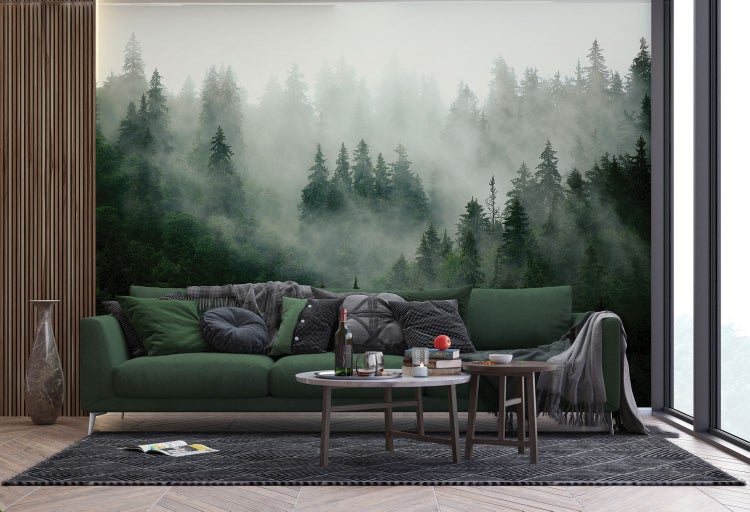 Wohnzimmer mit grüner Couch, Couchtischen und Waldtapete