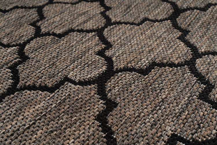 Nahaufnahme eines gewebten Teppichs mit geometrischem Muster und strukturierter Oberfläche.