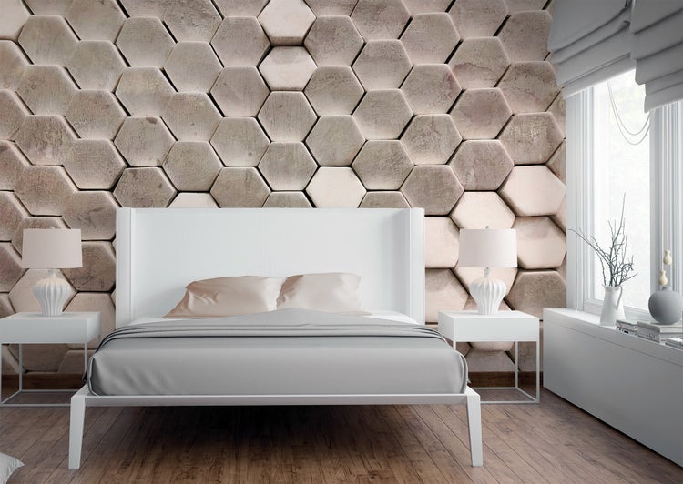 Modernes Schlafzimmer mit Bett, Nachttischen und Lampen. Wand mit großflächigem dreidimensionalem Sechseckmuster. Holzboden.