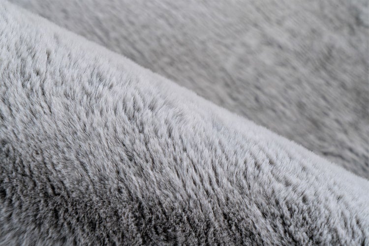 Grauer Kunstfell-Teppich aus weichen, dichten Synthetikfasern.