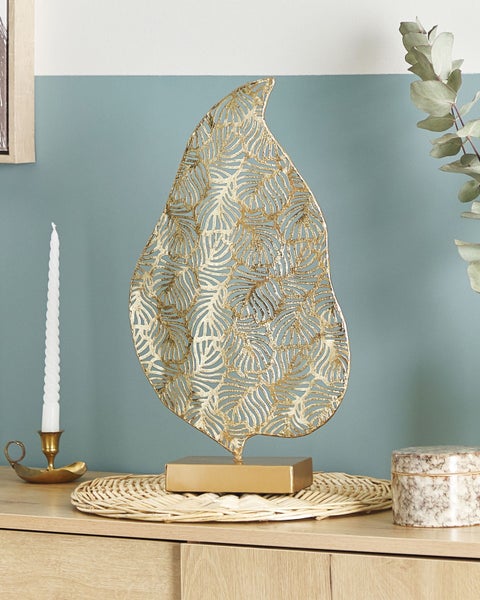 Dekorative goldfarbene Blattfigur auf Kommode