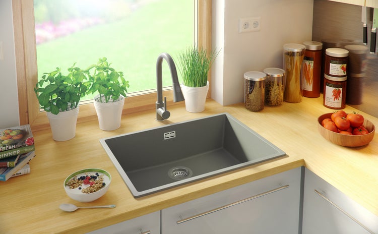 Küchenspüle aus Verbundmaterial mit Abtropffläche und Küchenarmatur auf einer Arbeitsplatte