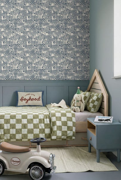 Kinderzimmer mit Zebra-Tapete oben und blauer Wandvertäfelung unten. Holz-Hausbett, karierte Bettwäsche und hellblaue Nachtkonsole.