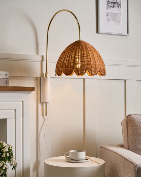 Wandleuchte mit Lampenschirm aus Rattan, montiert über einem Beistelltisch mit Tasse
