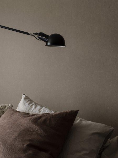 Dekorative Pflanzgefäße mit Pflanzen und einer Laterne auf einem Untergrund mit weißen Steinen.