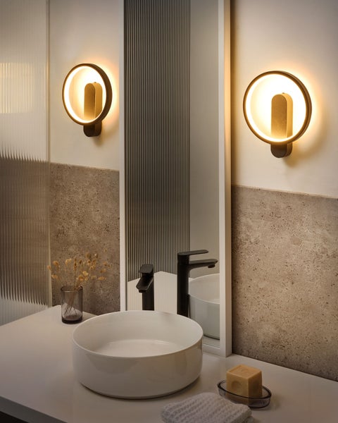 Modernes Badezimmer mit Waschbecken, Spiegel und zwei runden Wandleuchten