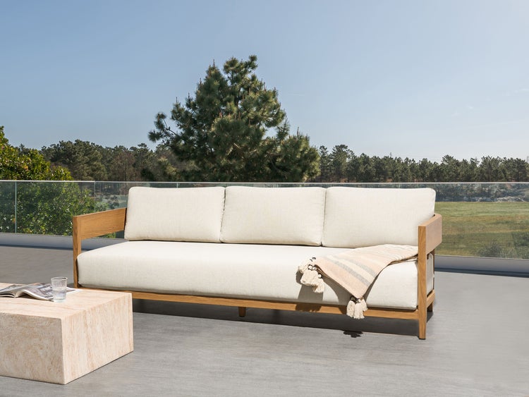 Drei-Personen-Gartensofa mit Holzbettung und hellen Kissen auf einer Terrasse mit Naturkulisse