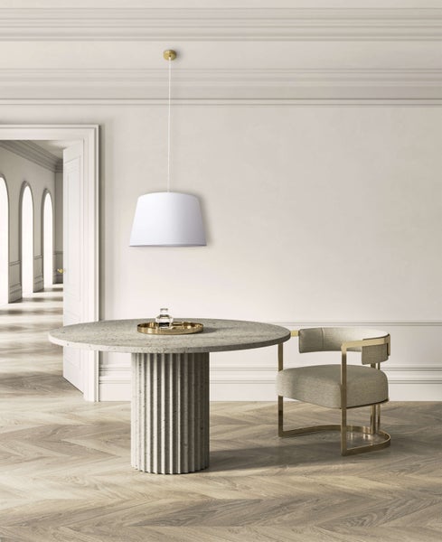 Heller Raum mit Esstisch aus Stein, Stuhl mit Metallrahmen und Pendelleuchte