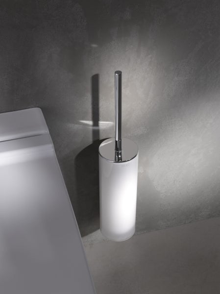 Wandmontierte KEUCO Toilettenbürstengarnitur aus Metall mit Griff und Halter in moderner Optik neben einer Toilette.