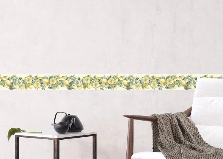 Selbstklebende Tapetenborte mit Zitronen-Motiv und grünen Blättern an einer hellen Wand in einem modern eingerichteten Wohnbereich.