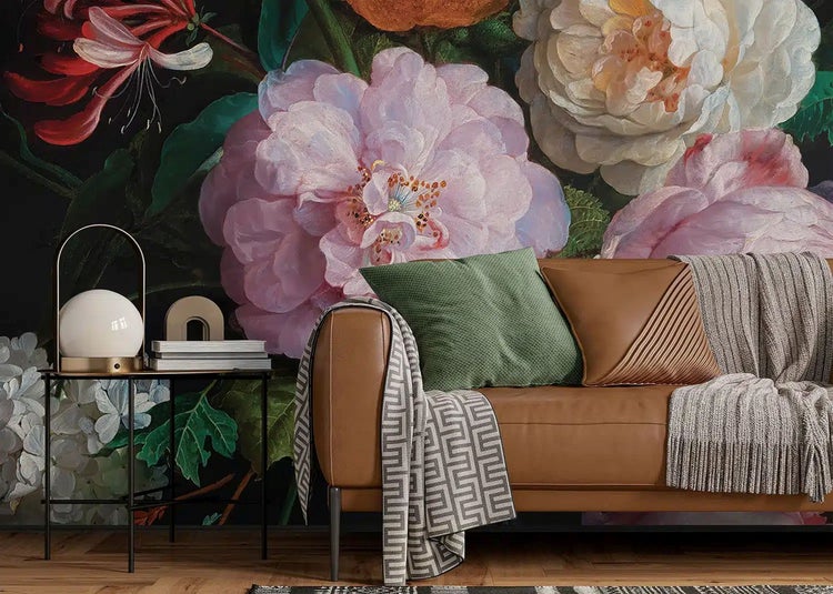 Fototapete mit großem Blumenmuster hinter einem braunen Ledersofa im Wohnzimmer mit dekorativen Kissen und Beistelltisch.
