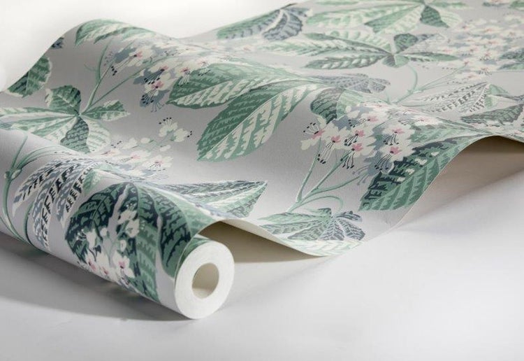 Wohnzimmer mit floral gemusterter Tapete, Sofa, Tisch und Bank