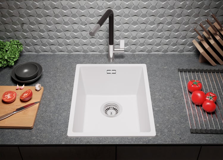 Küchenspüle aus hellem Material mit Armatur und Spülbeckenablauf