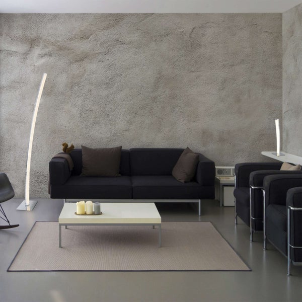 Wohnzimmer mit Sofa, Sessel, Stehlampe und Teppich