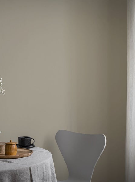 Wandgestaltung in dezentem Farbton mit gedecktem Tisch und Stuhl