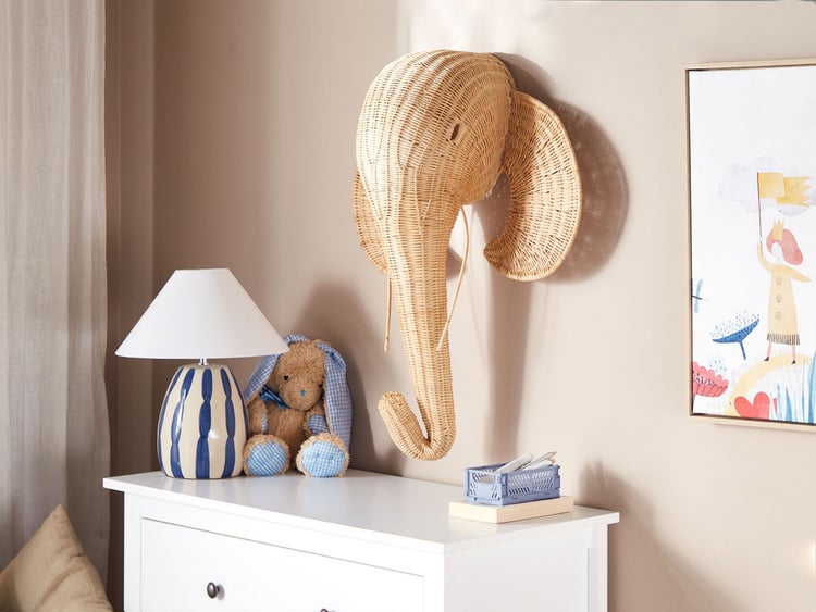 Dekoriertes Kinderzimmer mit Kommode, Lampe, Spielzeug und Wanddekoration