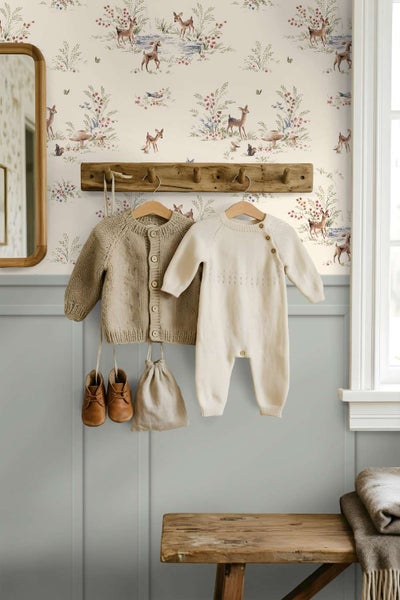 Vliestapete mit Waldmotiven und Rehen im Kinderzimmer mit Holzgarderobe und Kinderkleidung