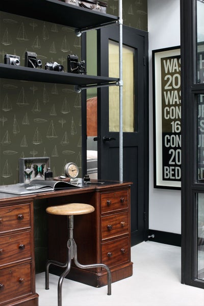 Vliestapete mit Segelboot-Muster in einem Arbeitszimmer mit antikem Holzschreibtisch und industriellem Metallregal.