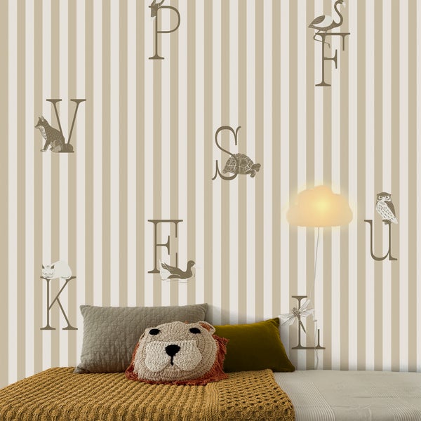 Gestreifte Kindertapete mit Buchstaben und Tieren, wandmontierte Wolkenlampe und Bett mit Kissen in einem hellen, organisierten Kinderzimmer.