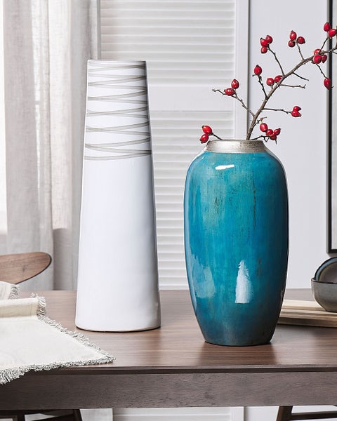 Dekorative Vasen auf einem Tisch, eine mit Zweigen und roten Beeren