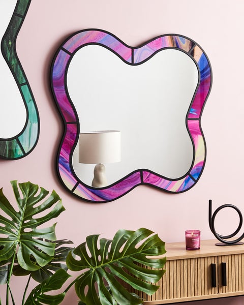 Dekorativer Spiegel mit gemustertem Rahmen im Wohnzimmer