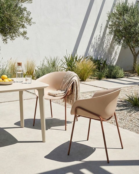 Terrassenszene mit Gartentisch und zwei Gartenstühlen auf Kies