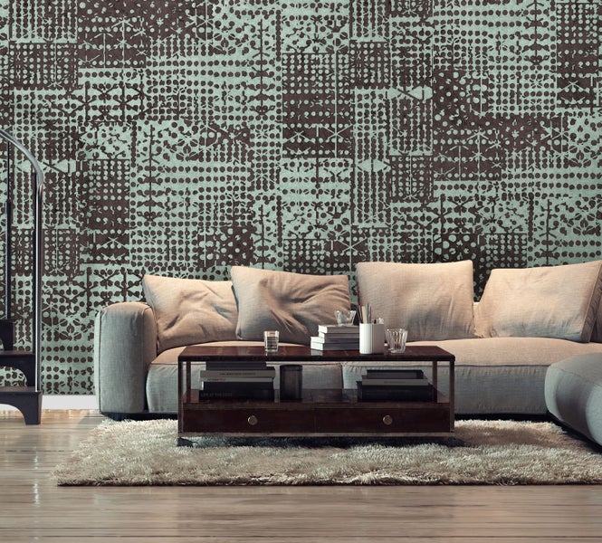 Wohnzimmer mit Sofa, Teppich und gemusterter Tapete