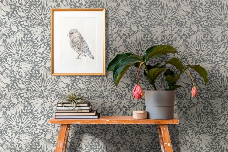 Schlafzimmer mit floral gemusterter Tapete, Nachttisch und Bett