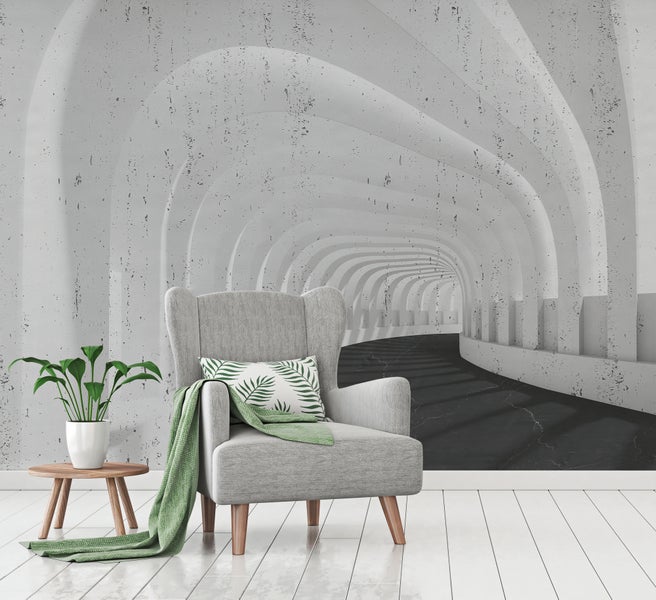 Fototapete mit 3D-Tunnel-Effekt in Betonoptik in einem modern eingerichteten Zimmer mit grauem Sessel und weißem Dielenboden.