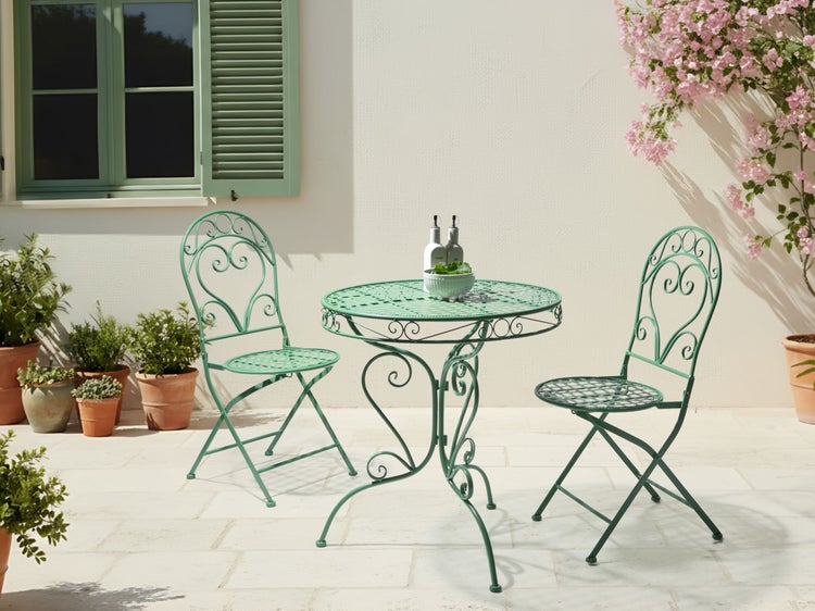 Gartenszene mit einem runden Gartentisch und zwei passenden Gartenstühlen aus Metall