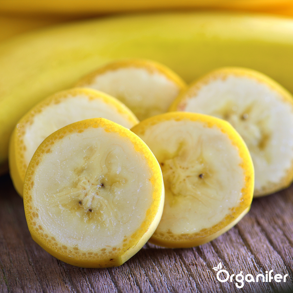 Bananenscheiben auf Holz mit Organifer Logo.