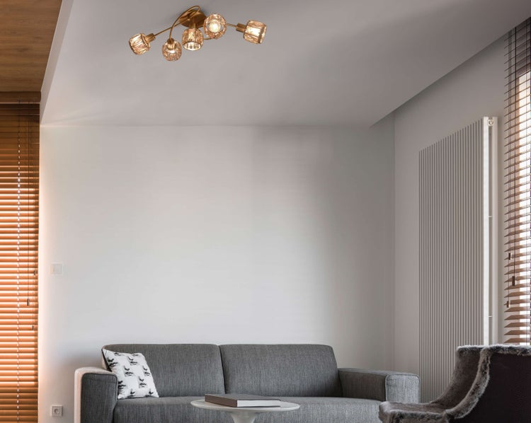 Wohnzimmer mit Sofa und Deckenleuchte mit mehreren Lampen