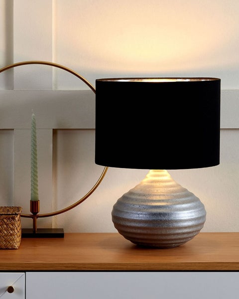 Tischleuchte mit silberfarbenem Fuß und schwarzem Lampenschirm