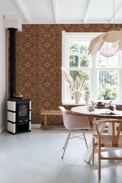 Wohnraum mit Ofen, Esstisch und gemusterter Tapete