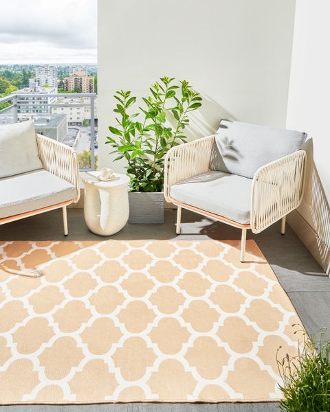 Rechteckiger Teppich mit weißem orientalischem Gittermuster auf beigem Untergrund.