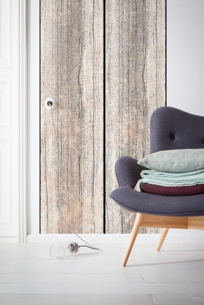 Wohnszene mit Holztapete, Sessel und Lampe