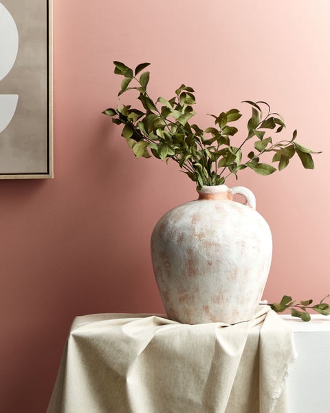 Dekorative Vase mit Pflanzen auf einem Tisch